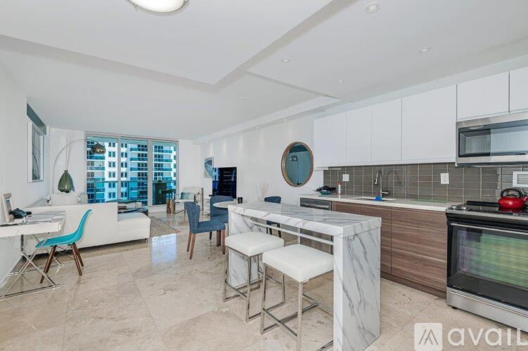 A kitchen with a white countertop and a white dining table with four chairs.