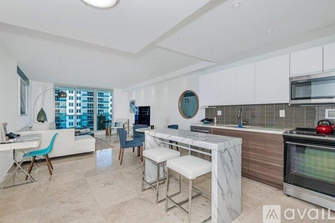 A kitchen with a white countertop and a white dining table with four chairs.