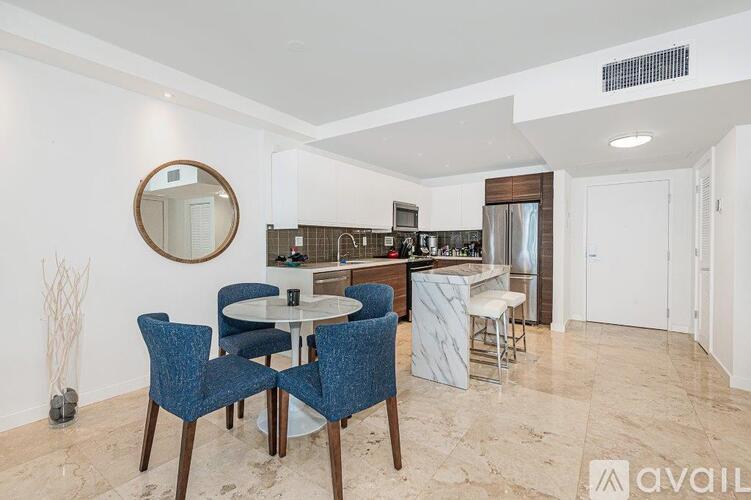 A dining area with a round table and blue chairs.