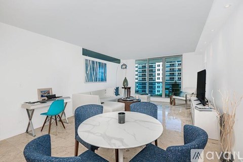 A living room with a white table and blue chairs.