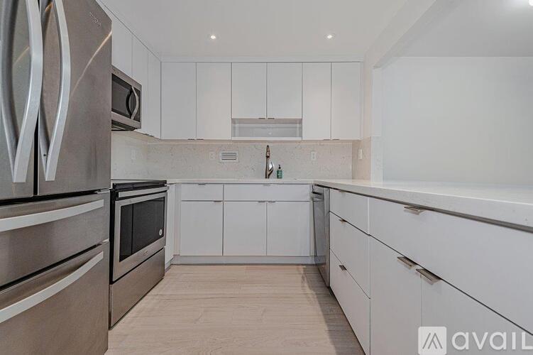 A kitchen with white cabinets and stainless steel appliances.