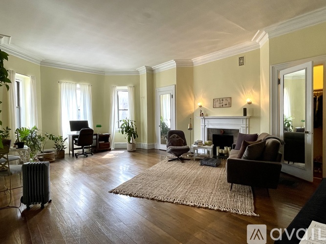 A living room with a fireplace and a rug on the floor.