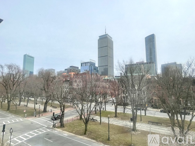 A cityscape with buildings and trees in the foreground.