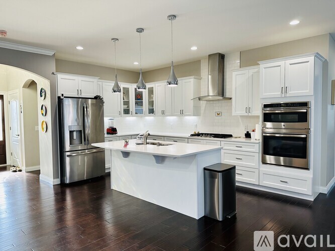 A modern kitchen with white cabinets and stainless steel appliances.