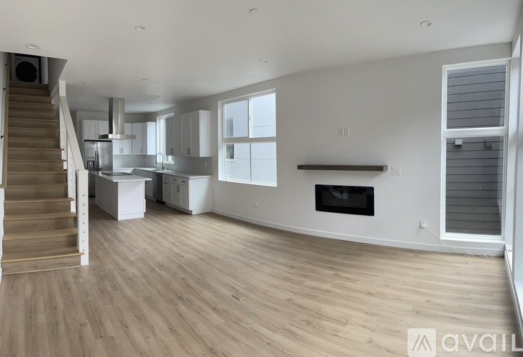 A spacious living room with a staircase leading to the upper floor.