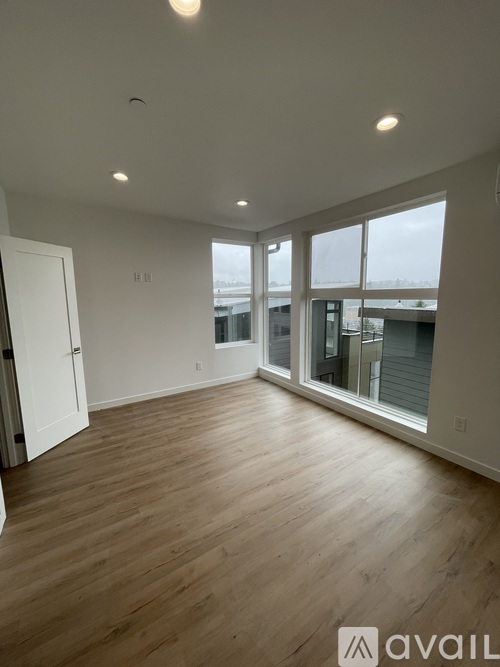 A room with wooden flooring and a large window.
