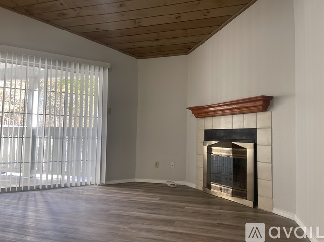 A room with a fireplace and wooden floors.