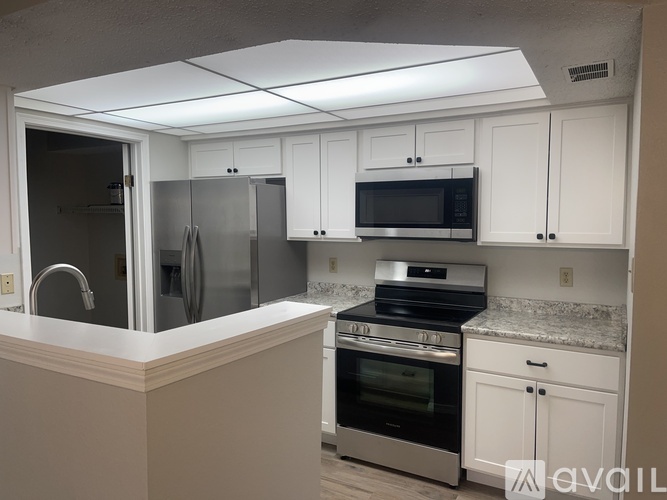 A kitchen with white cabinets and stainless steel appliances.