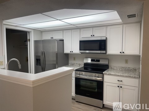 A kitchen with white cabinets and stainless steel appliances.