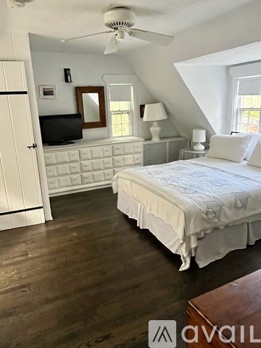 A bedroom with a bed, dresser, and tv.