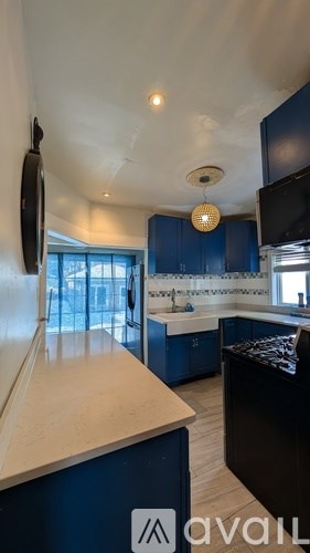 A kitchen with blue cabinets and a white countertop.