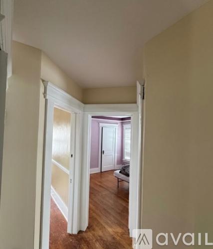 A hallway with a doorway leading to a bedroom.