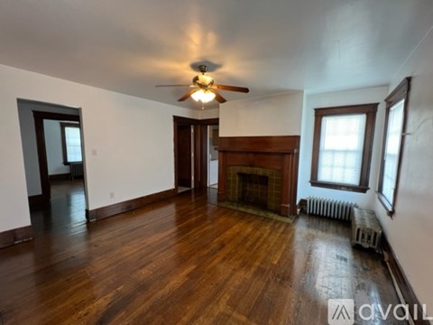 A room with wood floors and a fireplace is available for rent.