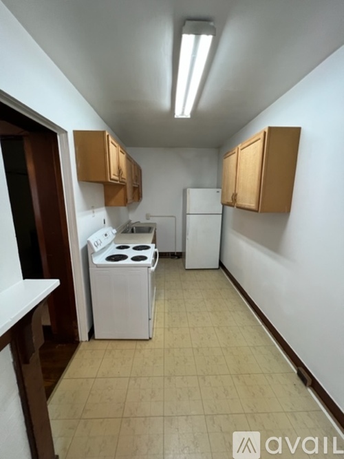 A kitchen with a white stove and a white refrigerator.