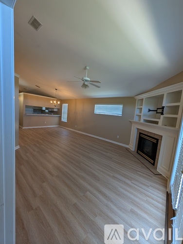 A spacious living room with a fireplace and built-in shelves.