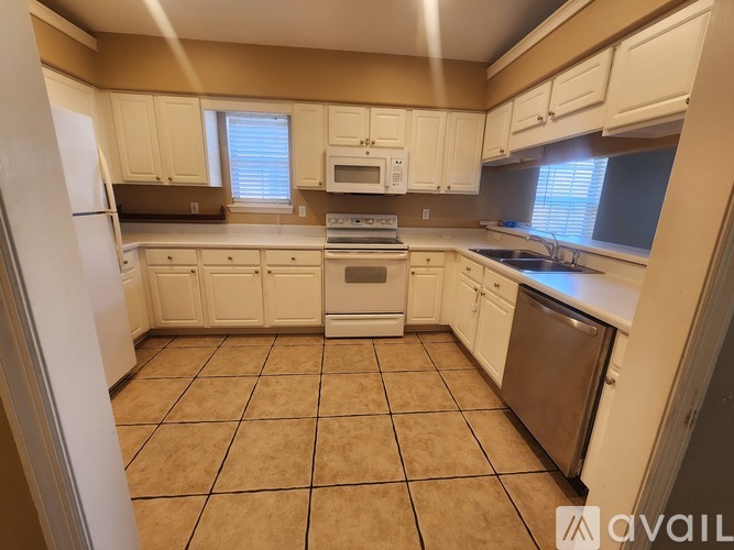 A kitchen with white cabinets and appliances.