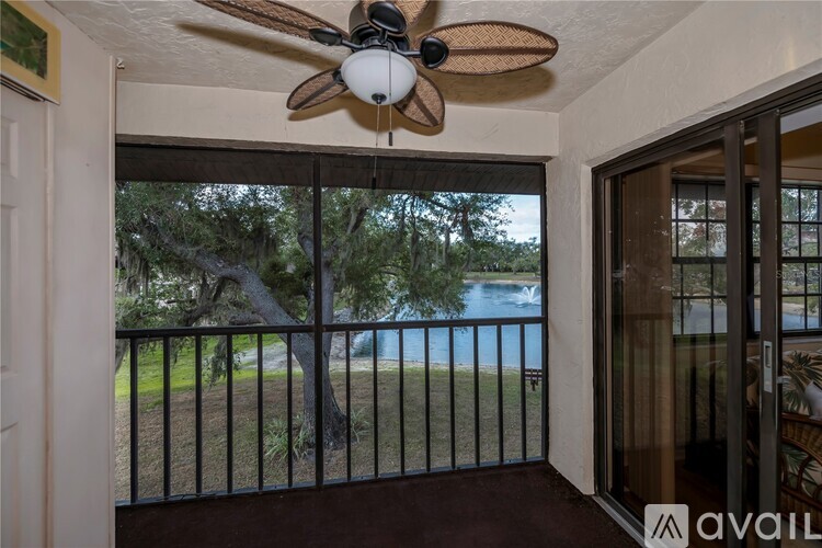 A room with a ceiling fan and a view of a pool through a sliding glass door.