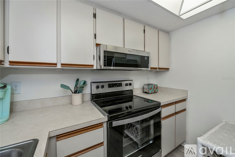 A kitchen with white cabinets and a black stove top oven.