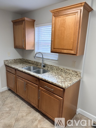 A kitchen with wooden cabinets and granite countertops.