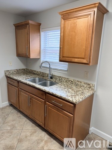 A kitchen with wooden cabinets and granite countertops.