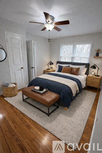A bedroom with a bed, a ceiling fan, and a rug.