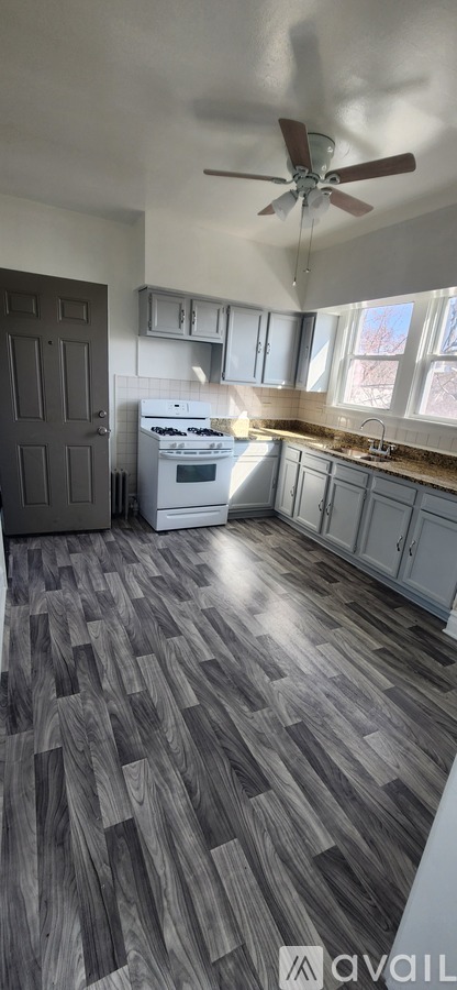 A kitchen with a fan and a stove top oven.