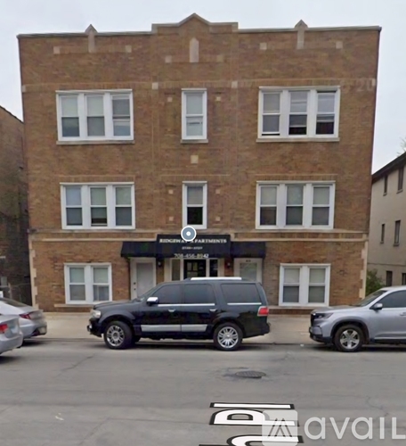 A black and white car is parked in front of a brick building.