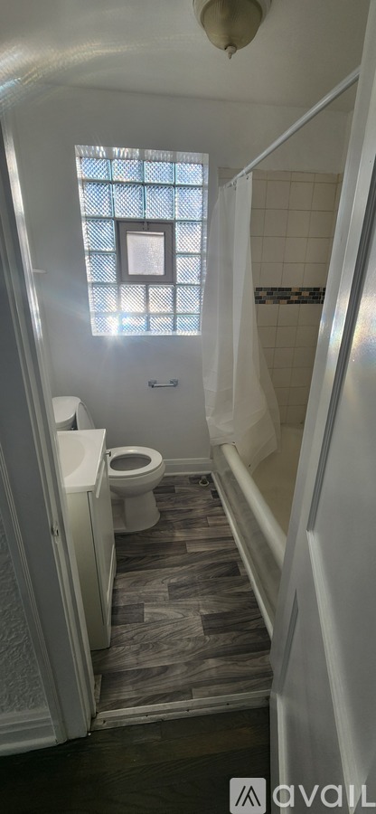 A bathroom with a toilet, a tub, and a window.