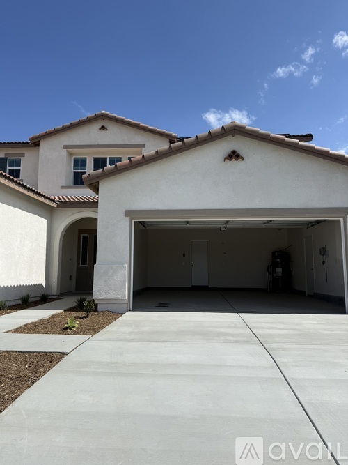 A white house with a garage door open.