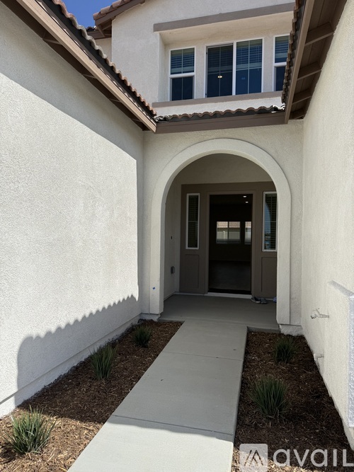 A white house with a brown roof and a brown door.