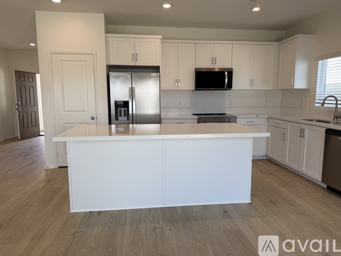 A modern kitchen with white cabinets and a central island.