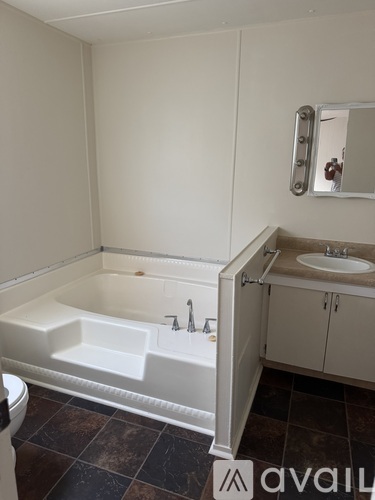 A bathroom with a sink, mirror, and cabinet.