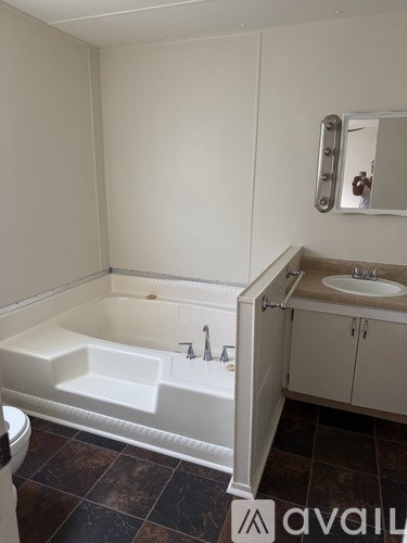 A bathroom with a sink, mirror, and cabinet.