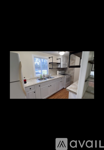 A kitchen with white cabinets and a window.