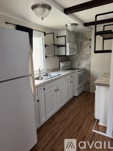 A kitchen with white cabinets and a window.