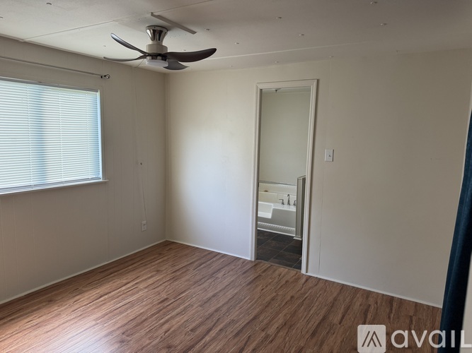 A room with wooden flooring and white walls.
