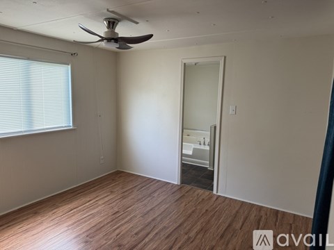 A room with wooden flooring and white walls.