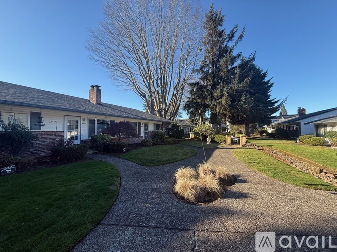 A house with a driveway and a tree in the front yard.