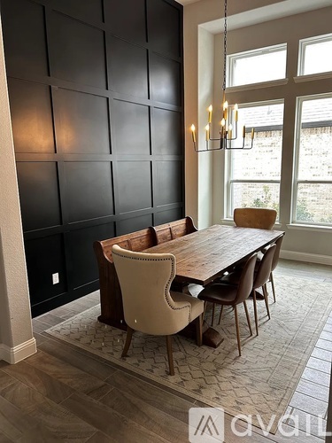 A dining room with a wooden table and chairs.