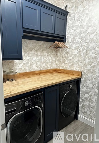 A kitchen with dark blue cabinets and a wooden countertop.