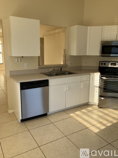 A kitchen with white cabinets and a stainless steel dishwasher.