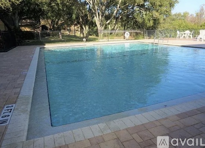 A rectangular pool with a white border and a brown tile floor.