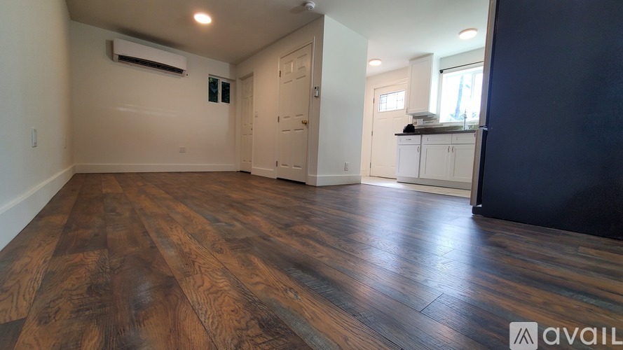 A room with wooden flooring and a white door.