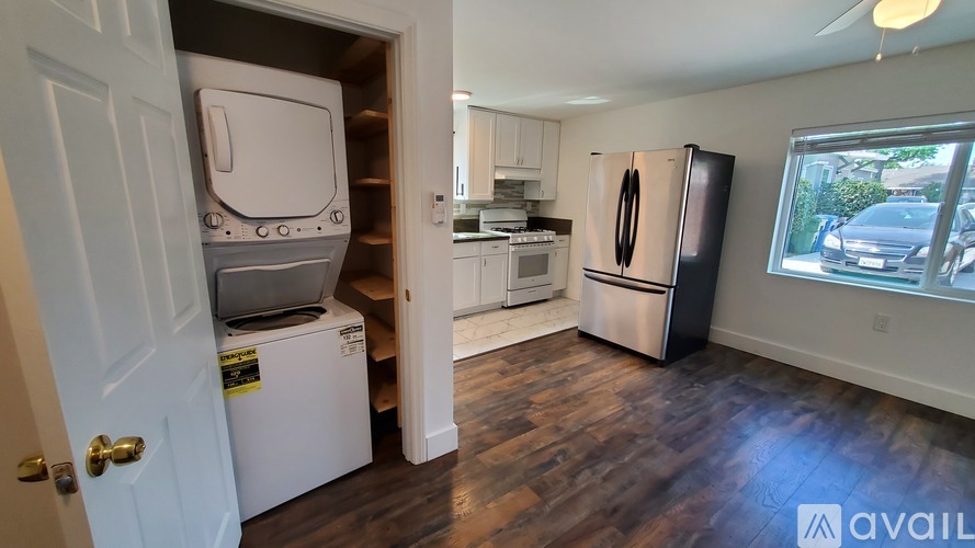 A kitchen with a white fridge and a white door.