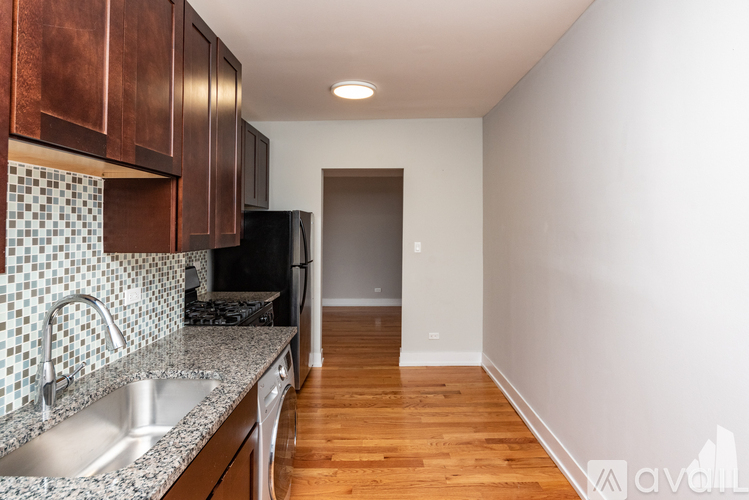 A kitchen with copper cabinets and a black fridge.