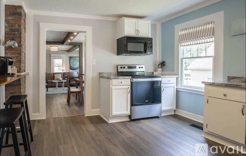 A kitchen with a brick wall and a white fridge.