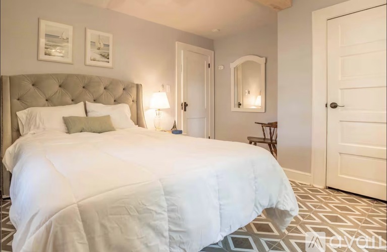 A bedroom with a large bed and a mirror on the wall.