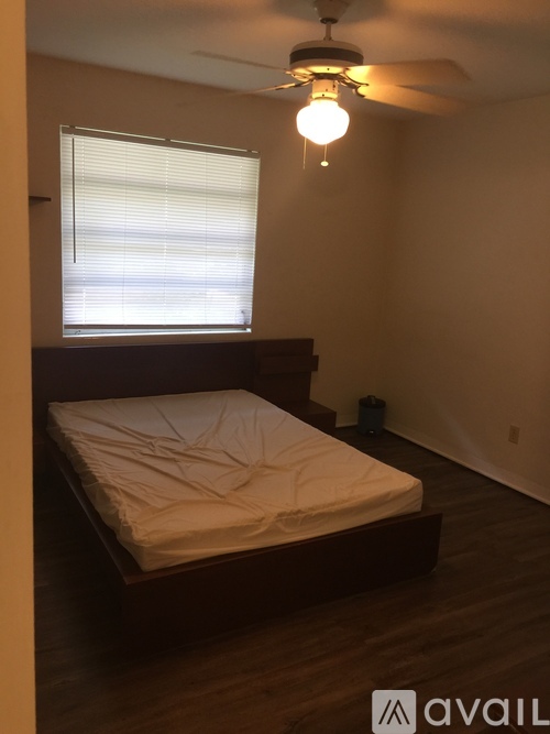 A bedroom with a bed and a ceiling fan.