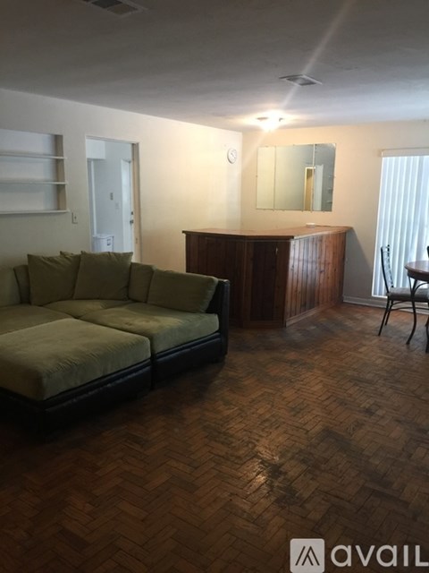 A living room with a couch and a wooden cabinet.