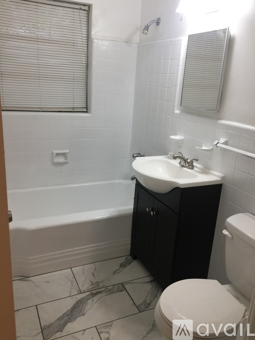 A bathroom with a marble floor and white walls.